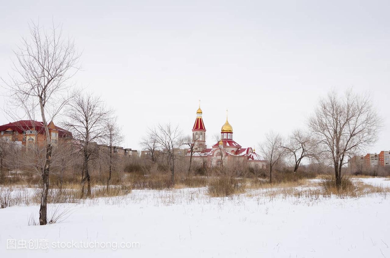 冬天在杂草丛生的荒地上的东正教教堂。这张照