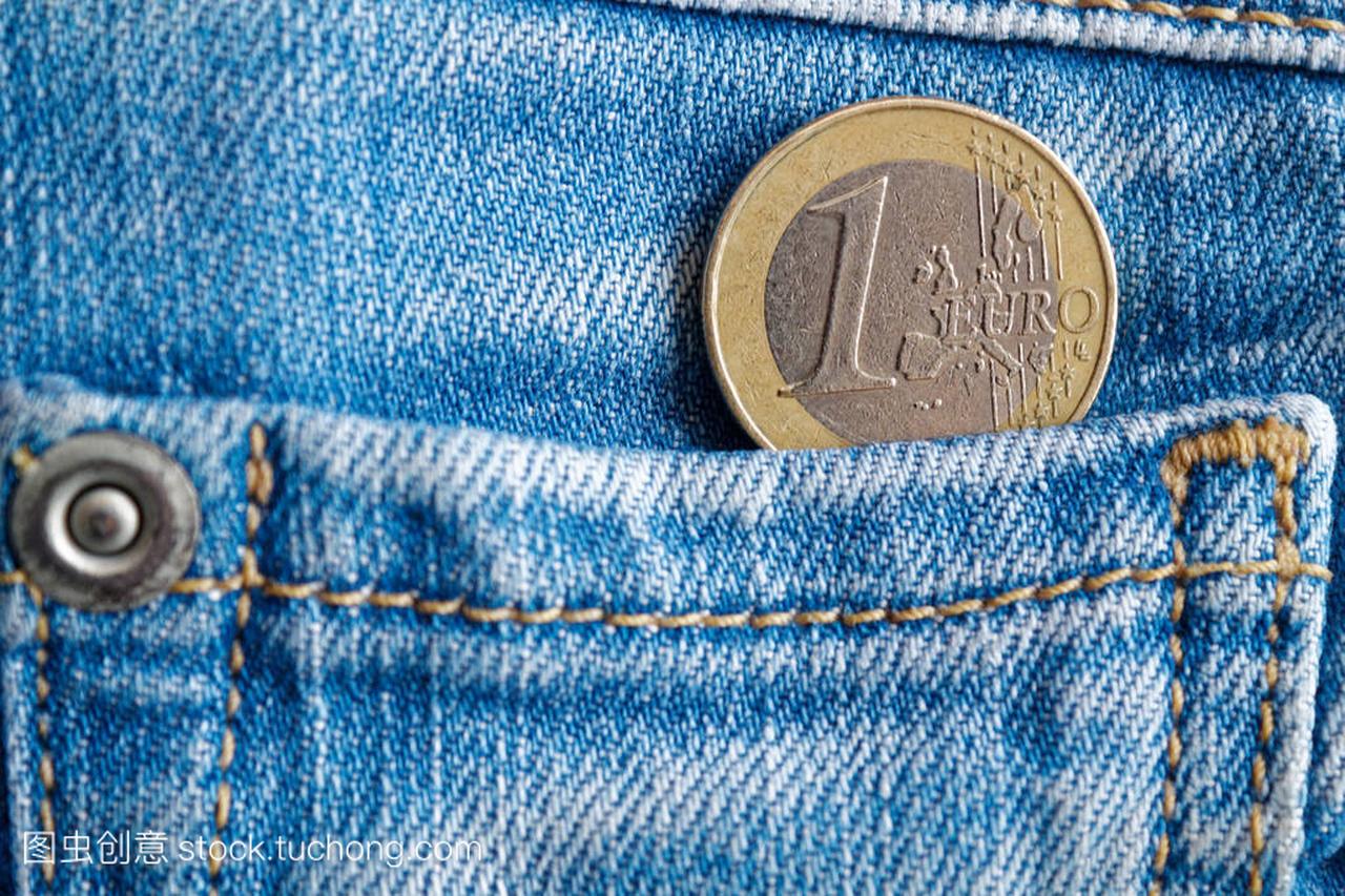 欧元硬币与一欧元面额的旧破旧的蓝色牛仔牛仔
