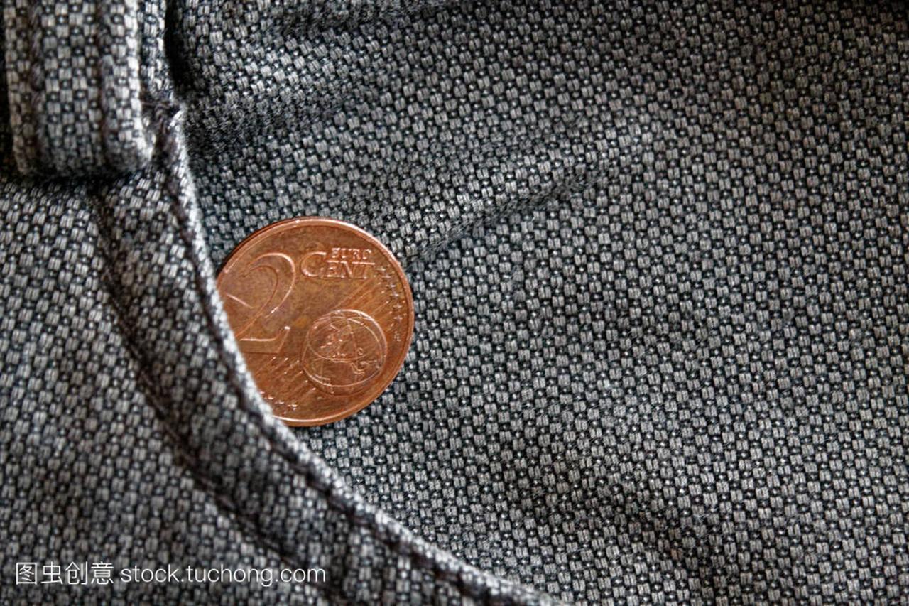 欧元硬币与两个欧元的面额在破旧的棕色牛仔牛