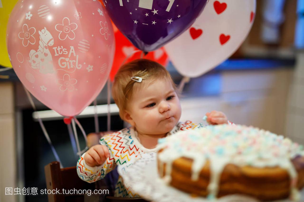 可爱的小女孩庆祝第一个生日。婴孩吃 marshm