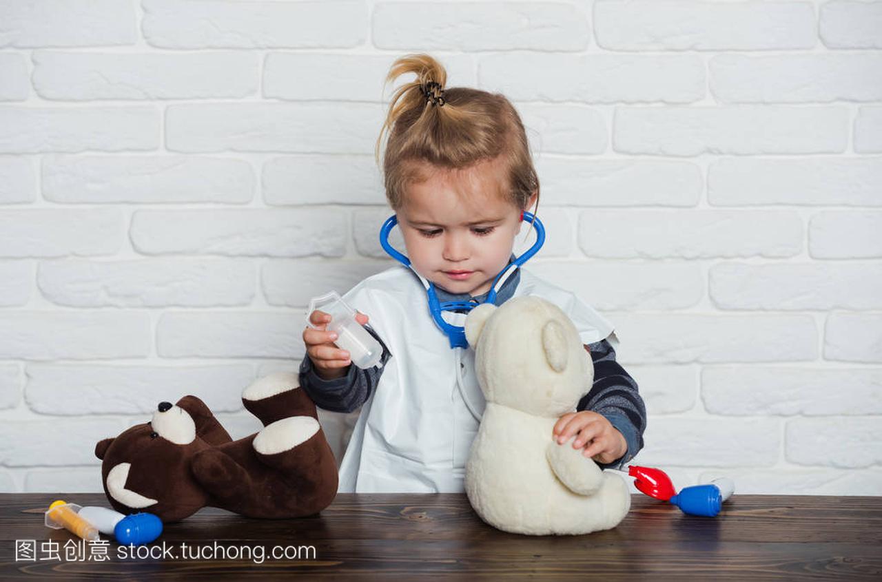 孩子在白墙上玩泰迪熊玩具的兽医医生。未来的