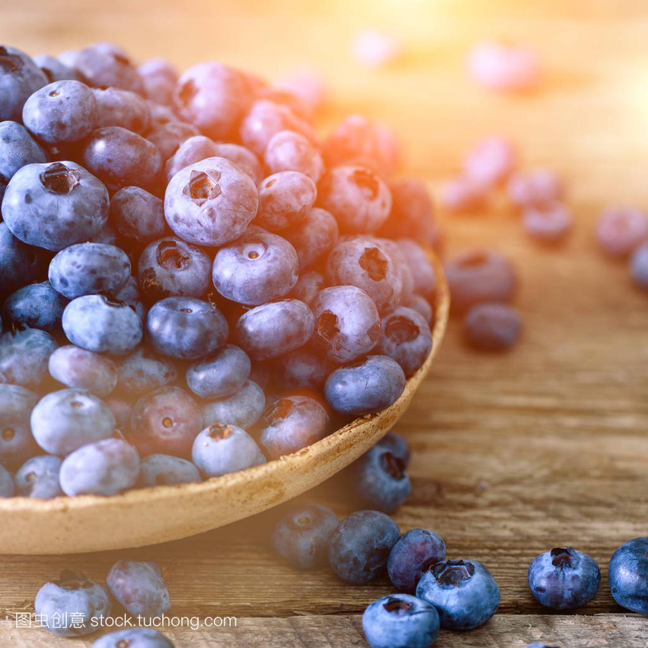 木桌上的蓝莓。与 copyspace 的葡萄酒背景蓝