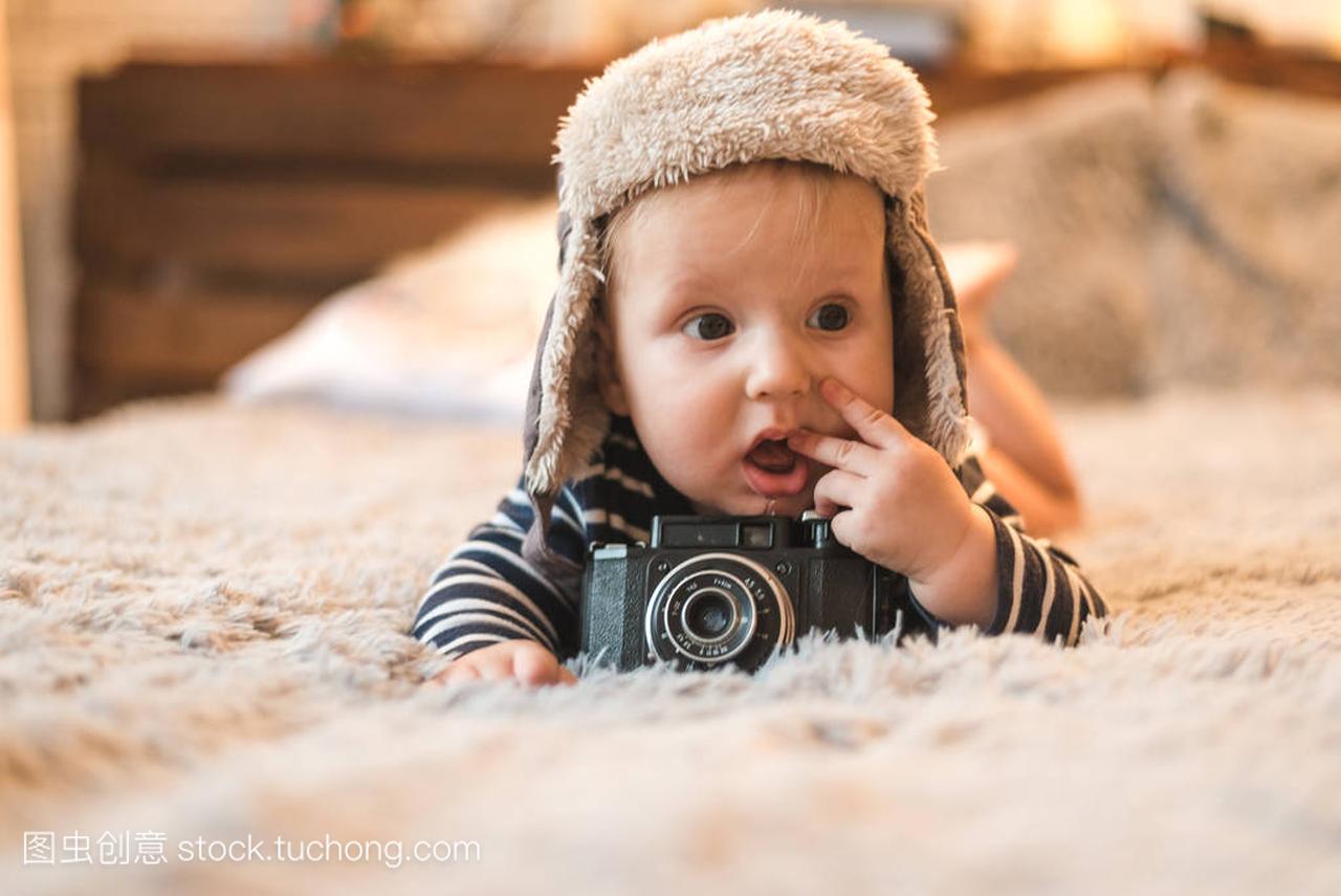 一个可爱的男孩在手与复古照片相机的肖像
