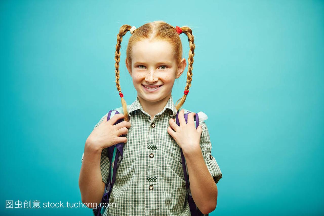 开朗的红头发女孩与雀斑和收集头发辫子与学校