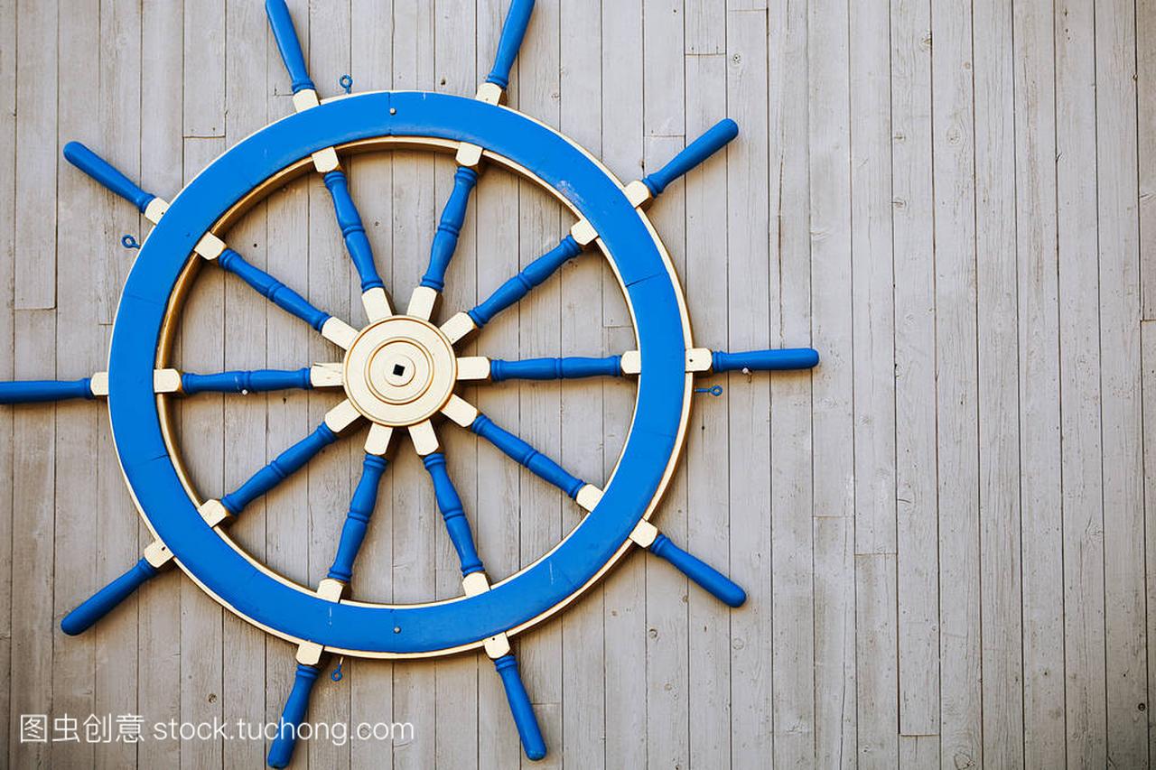 在墙上旧复古蓝色木制舵轮