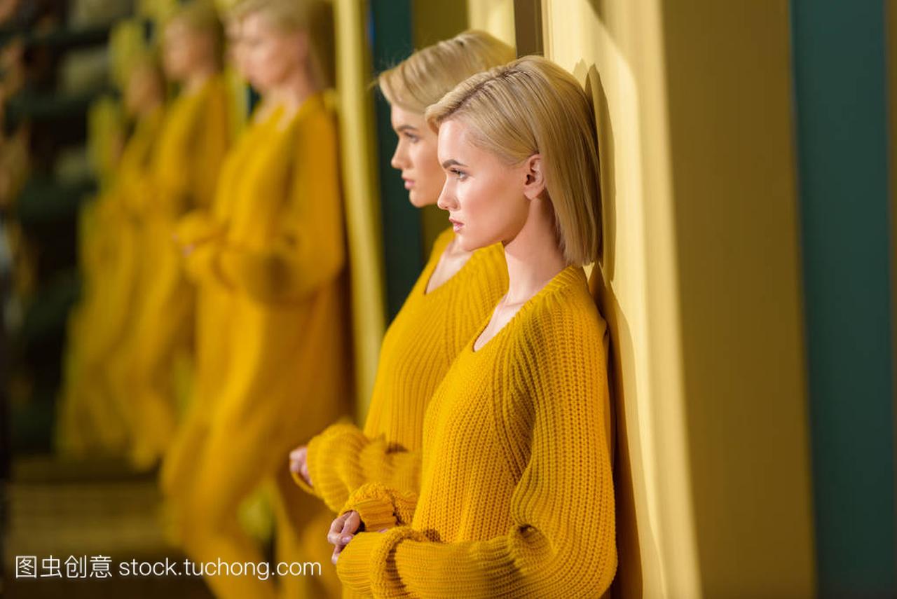 金发女人的选择焦点在黄色毛衣和紧身衣站在镜