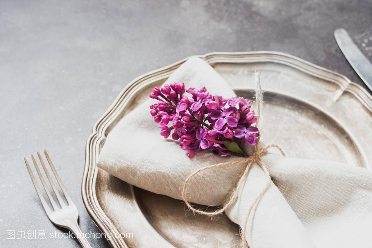 春天典雅桌地方设置与紫罗兰色丁香花, 银器在