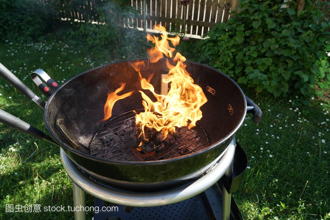 在烤架上开火, 在花园里烧烤香肠和木炭