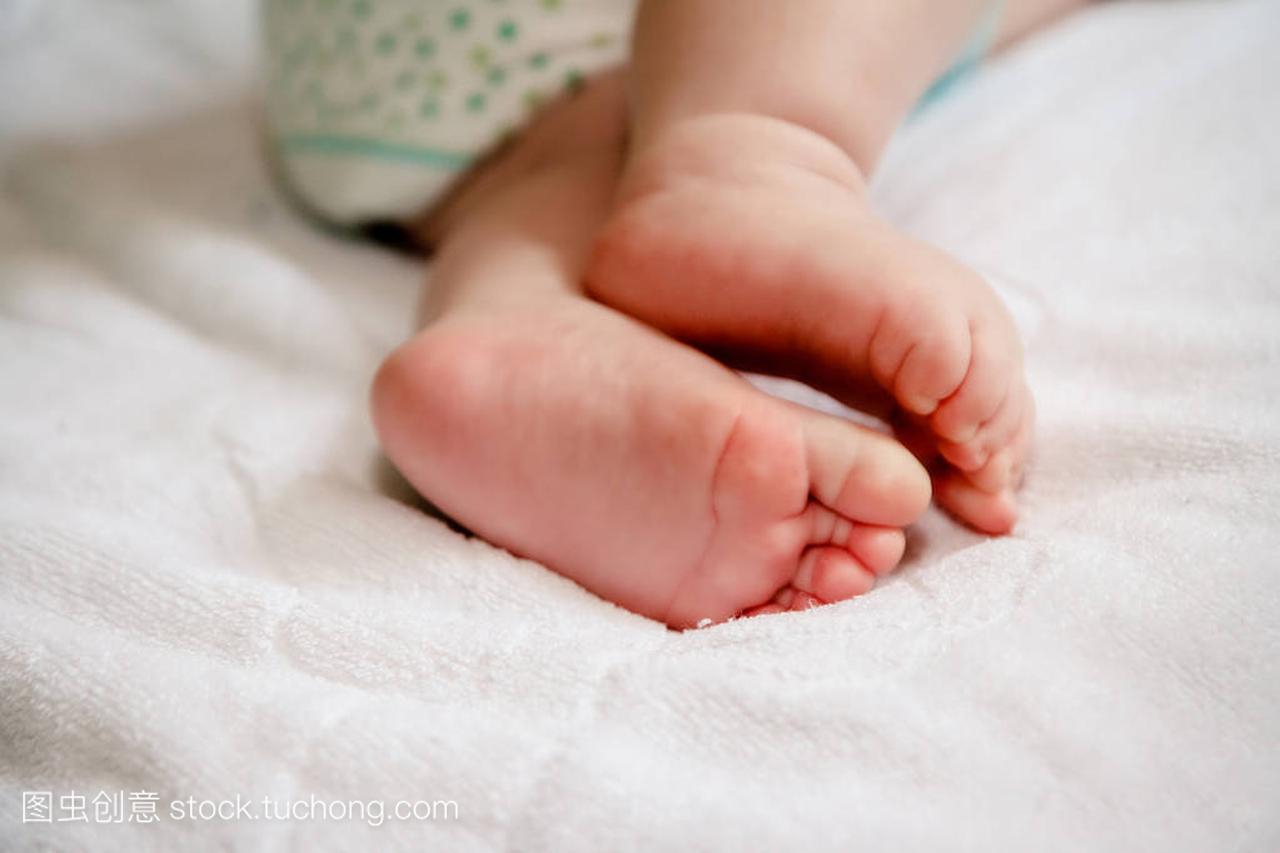 英尺的六个月大婴儿穿尿布躺在家里的床上
