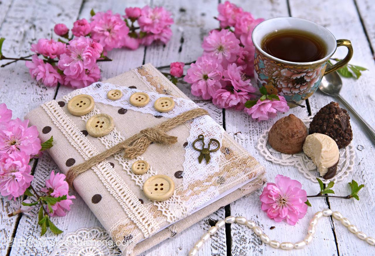 手工制作的日记本有樱花花、杯茶和 chokolate