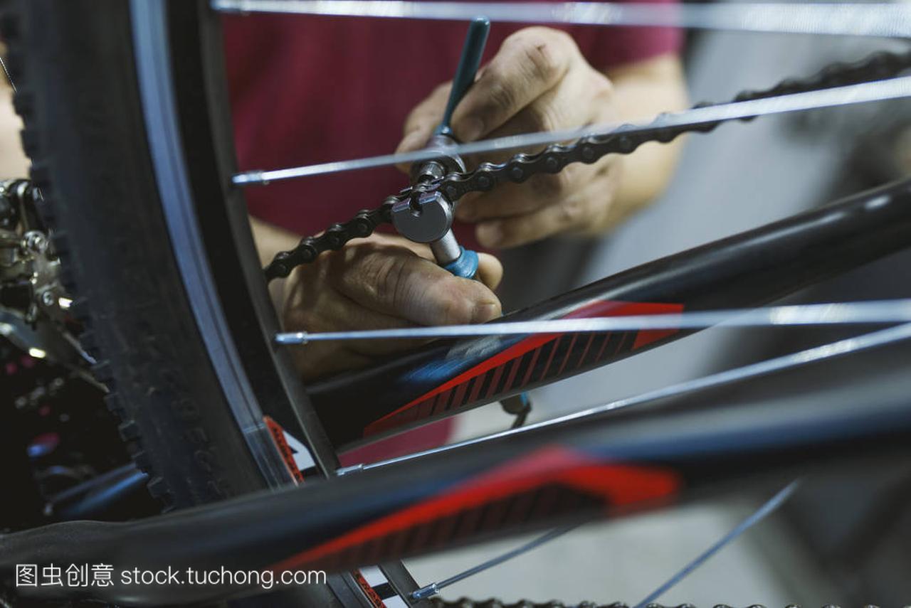 修理自行车链条的自行车维修店的机修工。机械
