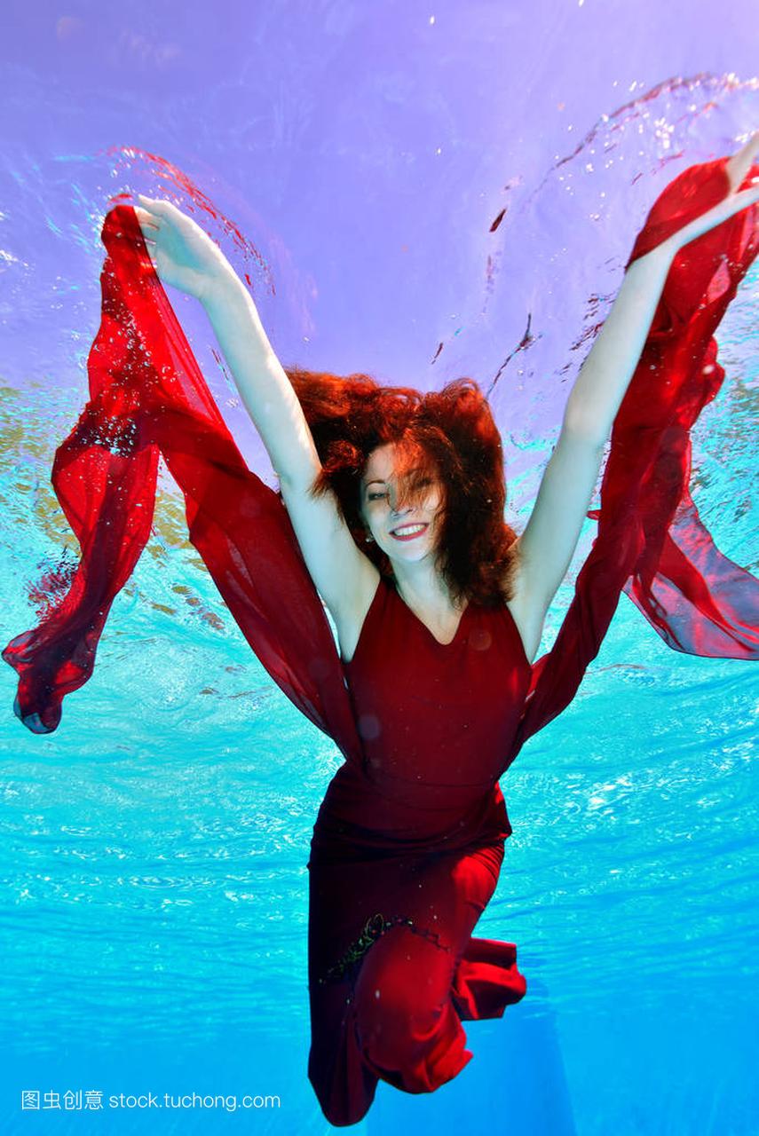 快乐女孩红头发游泳水下在泳池红色礼服紫色背