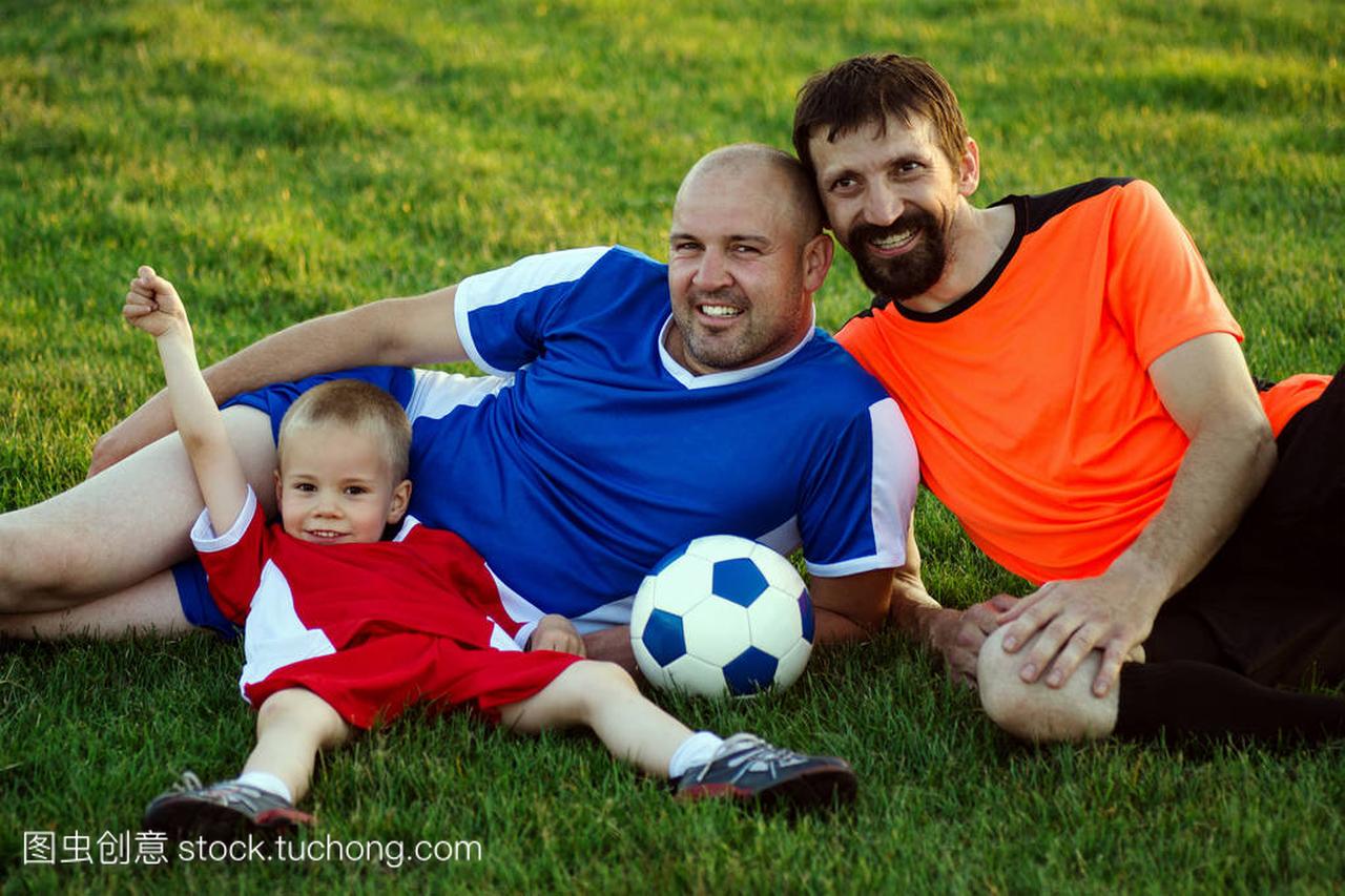 父亲, 儿子和叔叔从足球家庭是在球场上躺在草