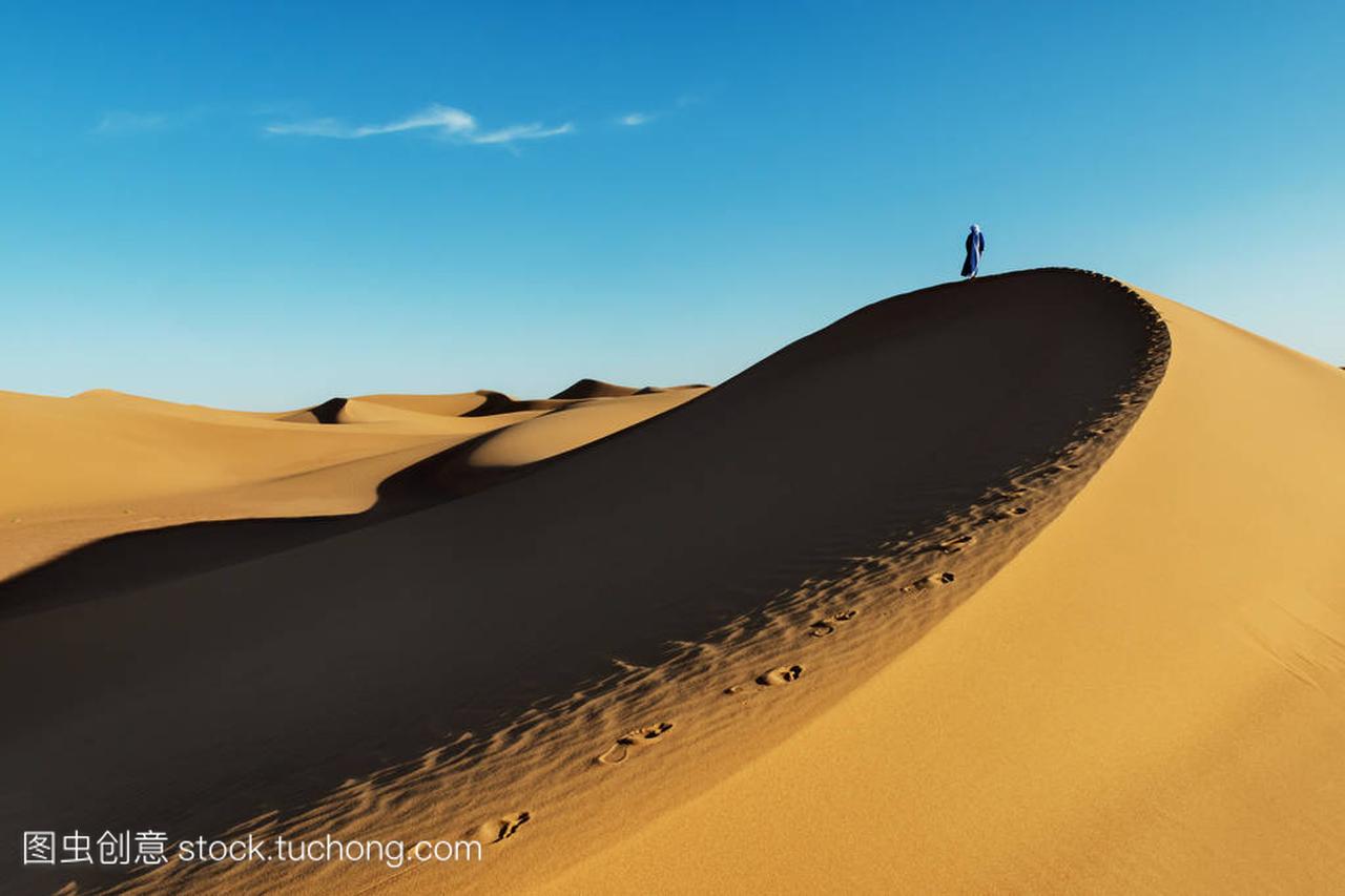 头巾传统着装摩洛哥男士站在一个沙丘在撒哈拉