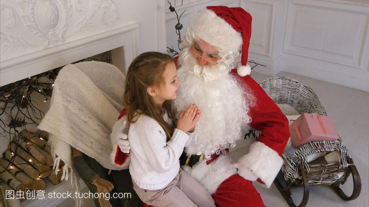 圣诞老人坐在一把椅子的小女孩梦见她圣诞礼物