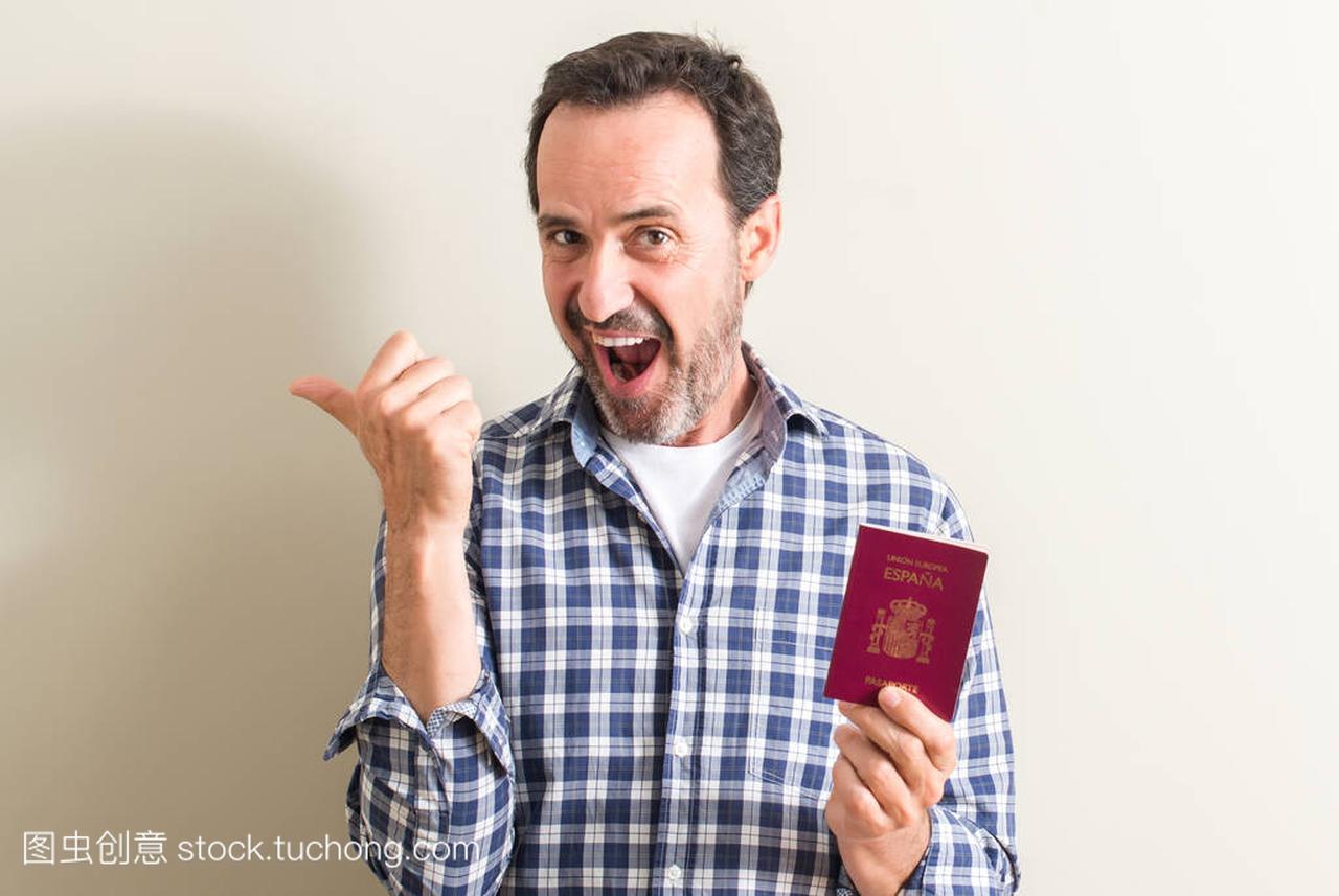 手持西班牙护照的资深男士用手指着笑脸微笑着