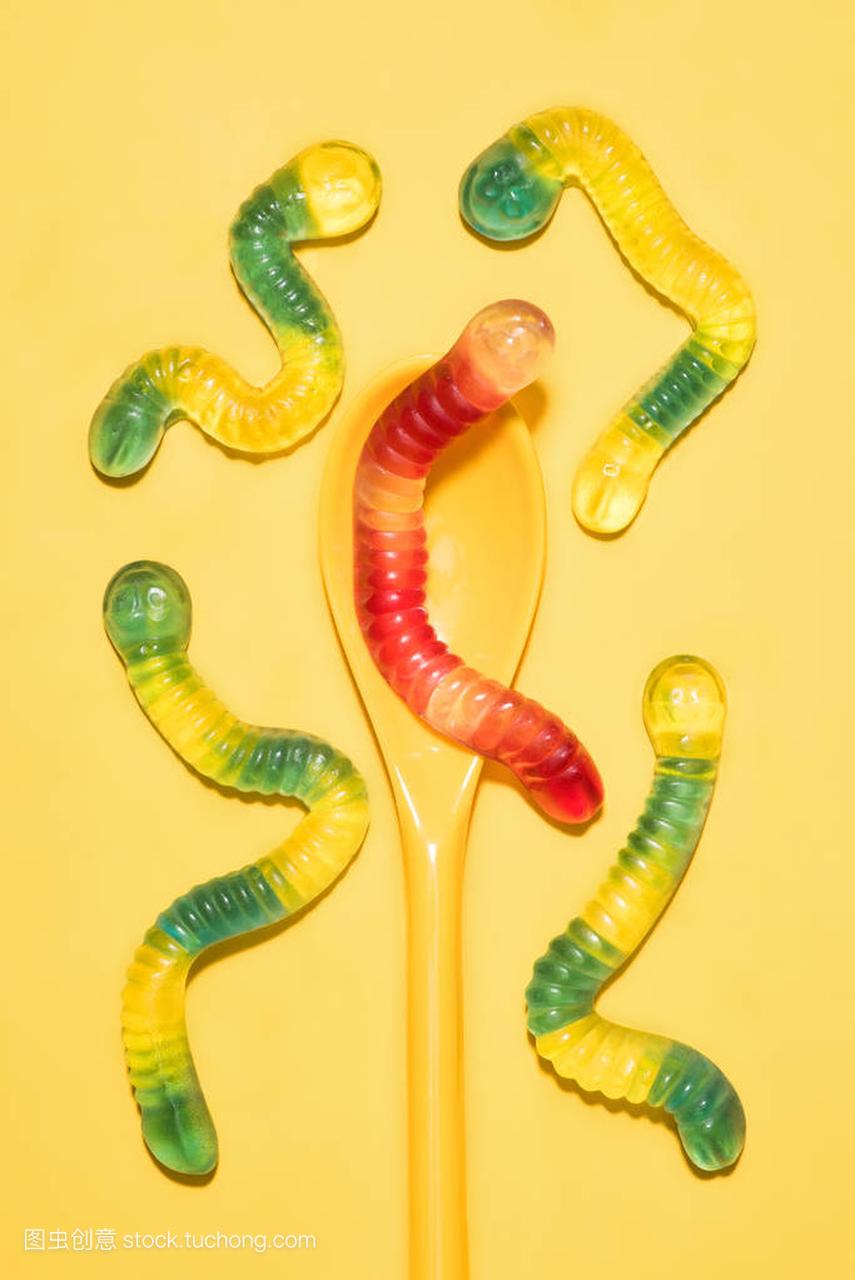top view of colorful gummy worms with spoon o