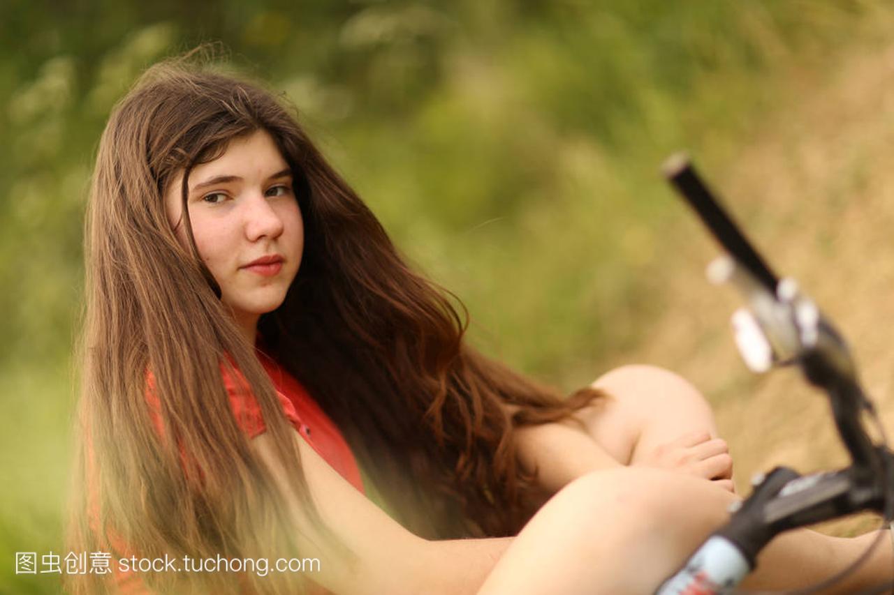 teenager girl ride bicycle on country road throug