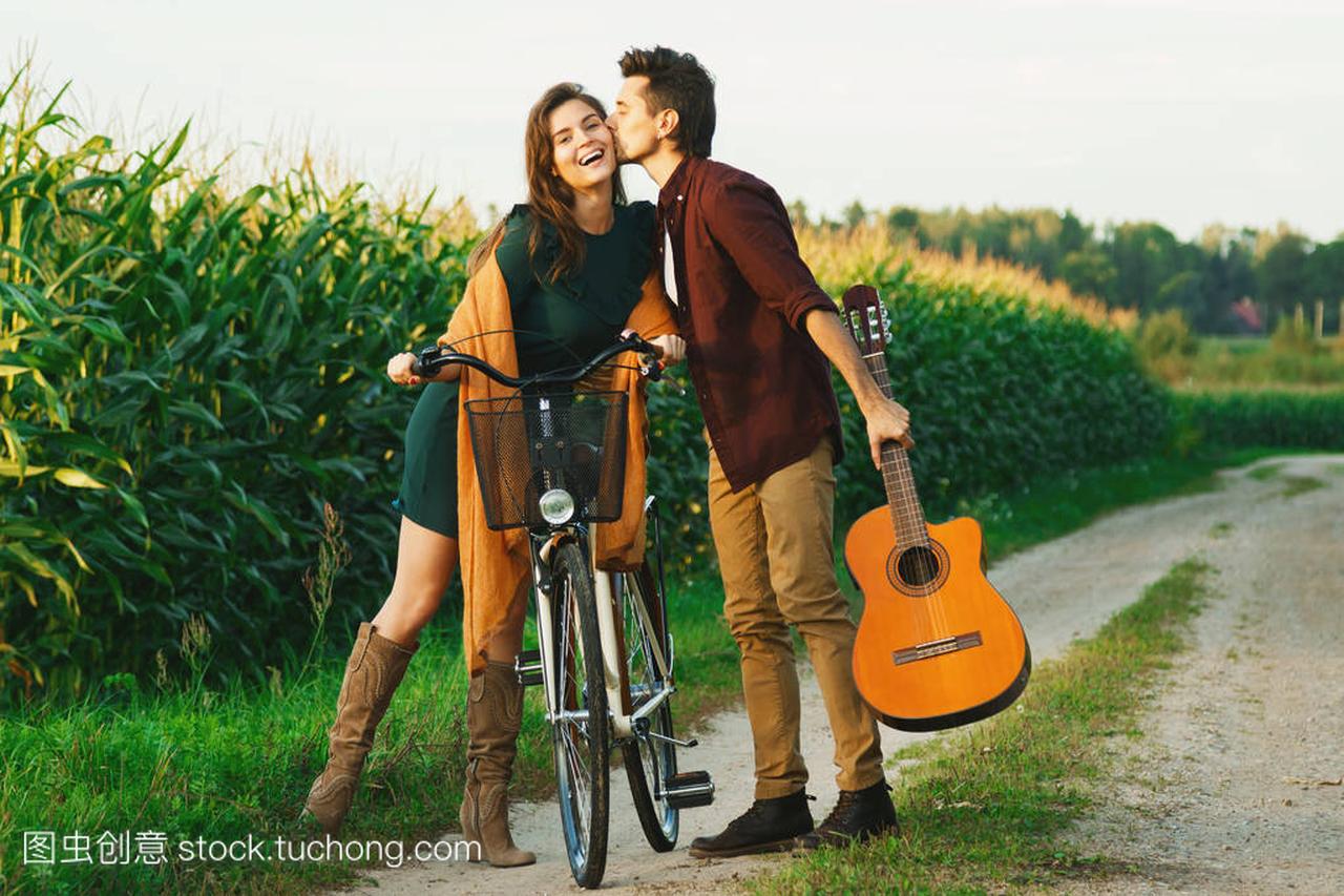 Young couple walking on country road. Girl ridin
