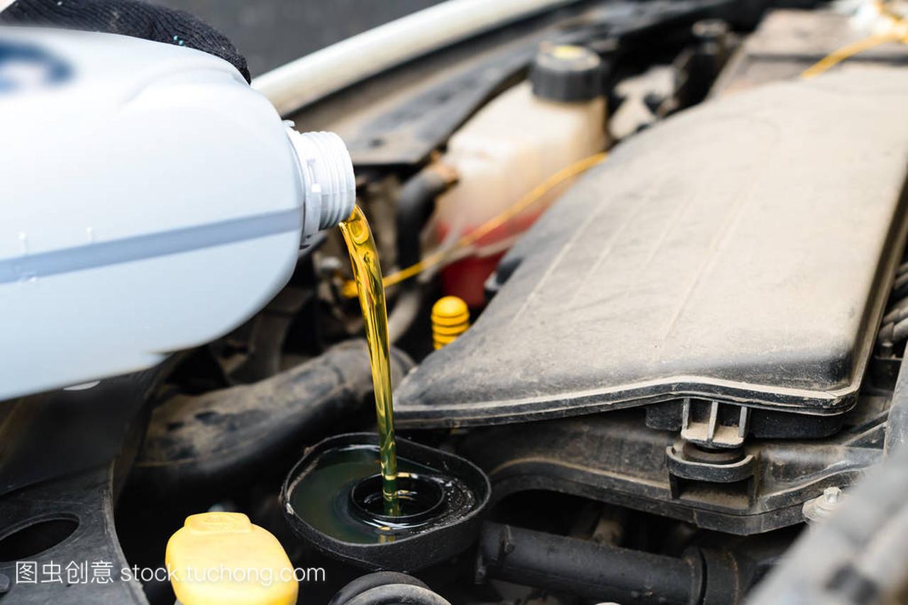 Fresh oil being poured during an oil change to c