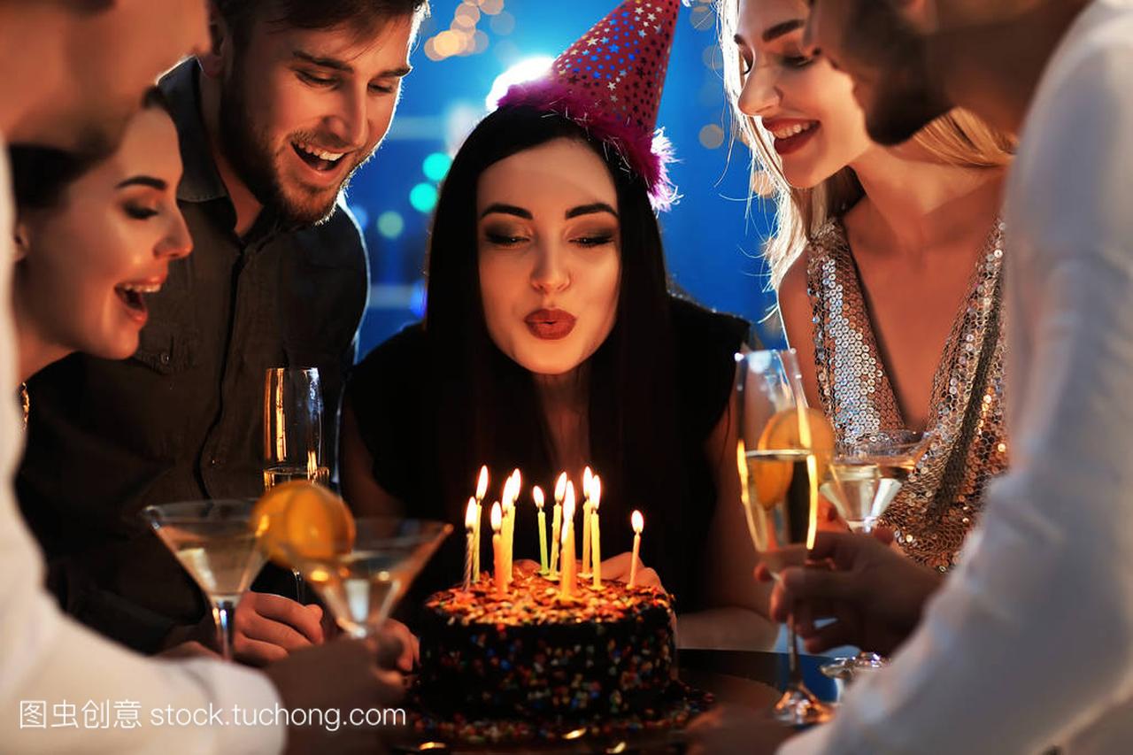 Young woman blowing out candles on her birthd