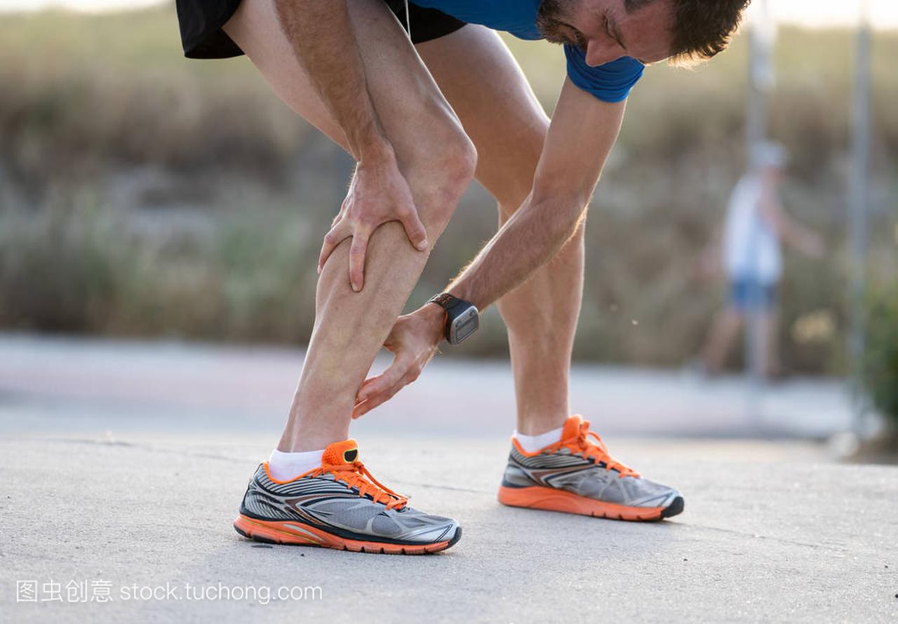 le runner touching painful twisted ankle, sprain c