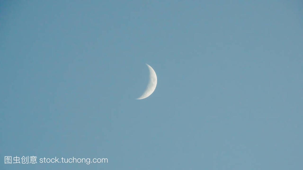 Crescent white moon on light blue sky. Minimal
