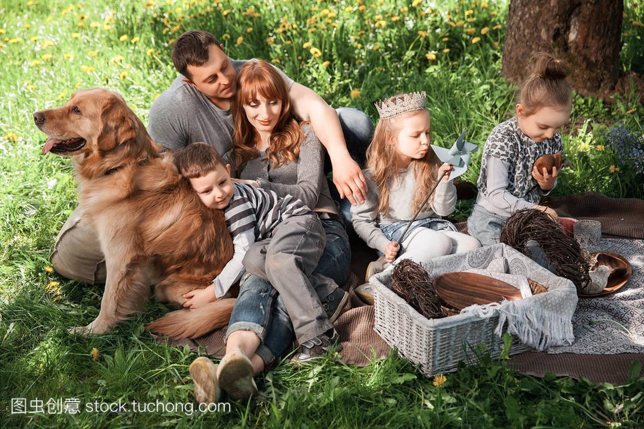 friendly, cheerful family on a picnic with a dog