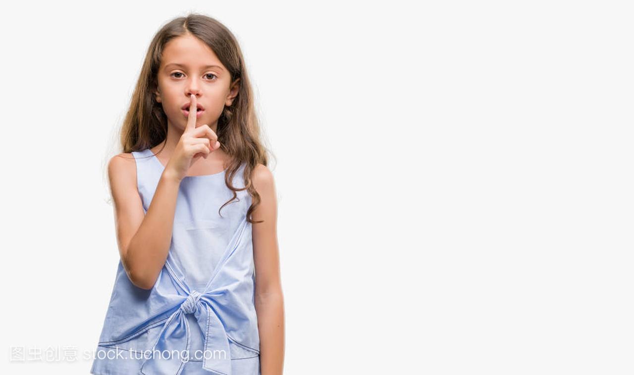 Brunette hispanic girl asking to be quiet with finger on lips. Silence and secret concept.