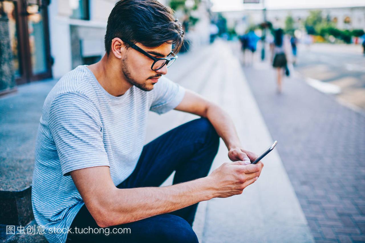 essed hipster guy in spectacles chatting online 