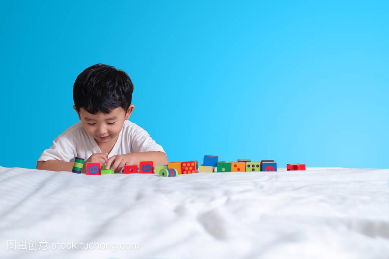 3岁的小可爱亚洲男孩玩玩具或方块拼图在家里