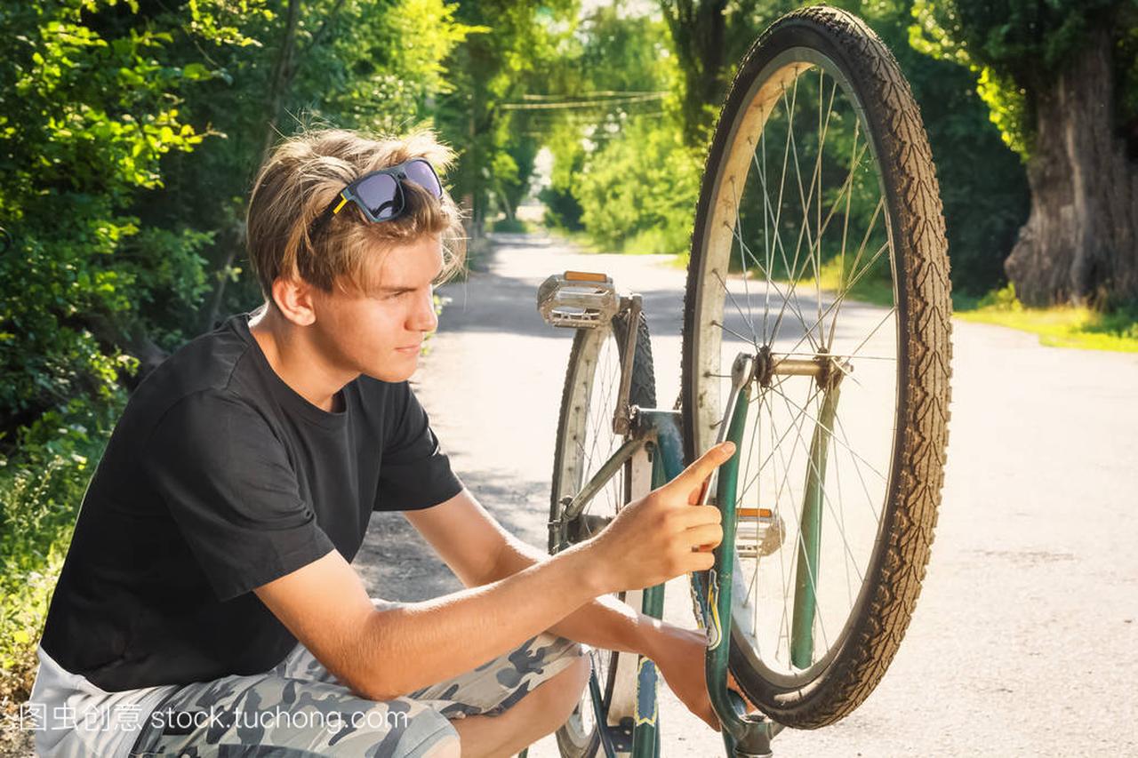 Guy repairs a bicycle on a country road in the c