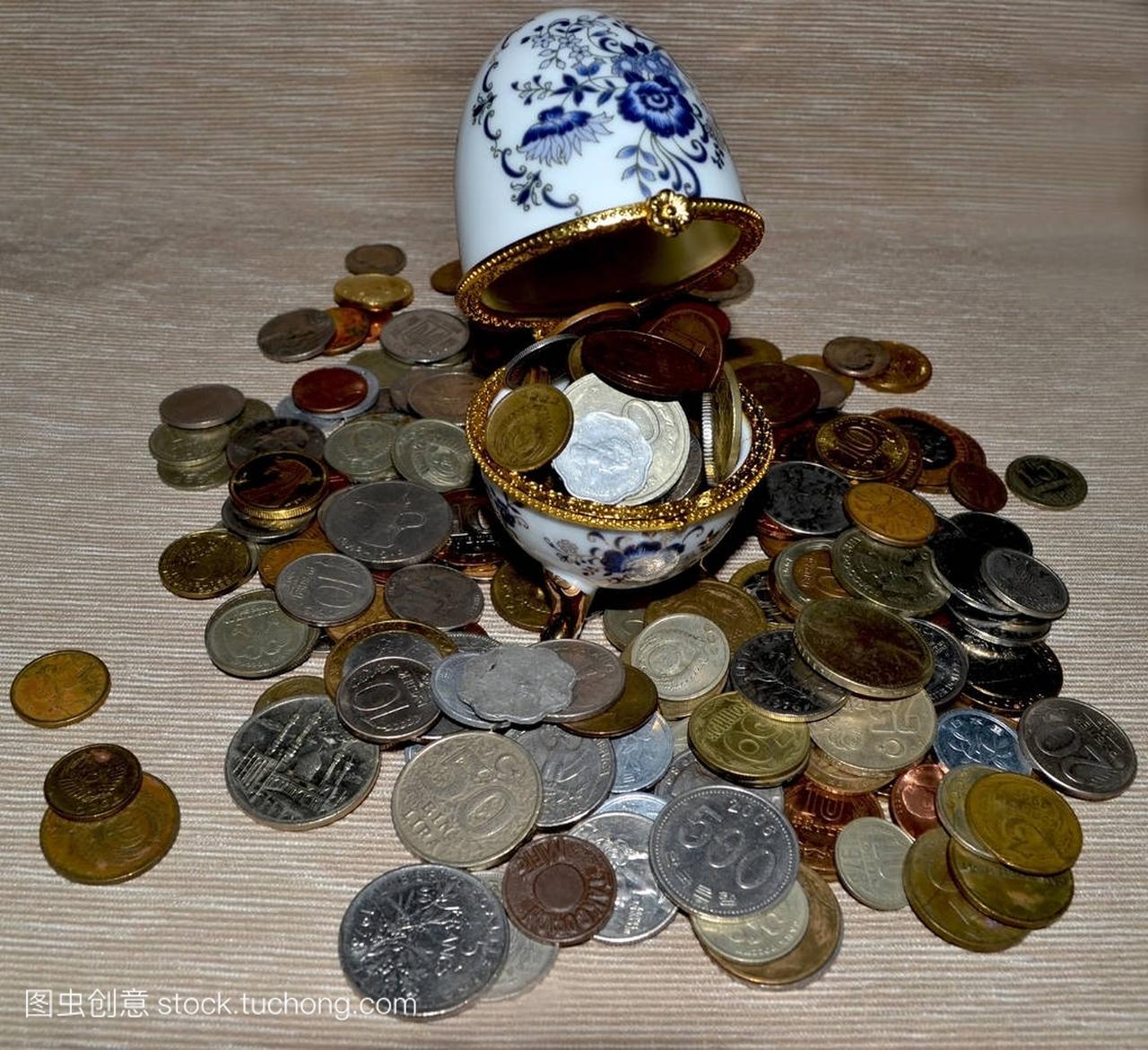 A scatter of coins and a white and blue box in th