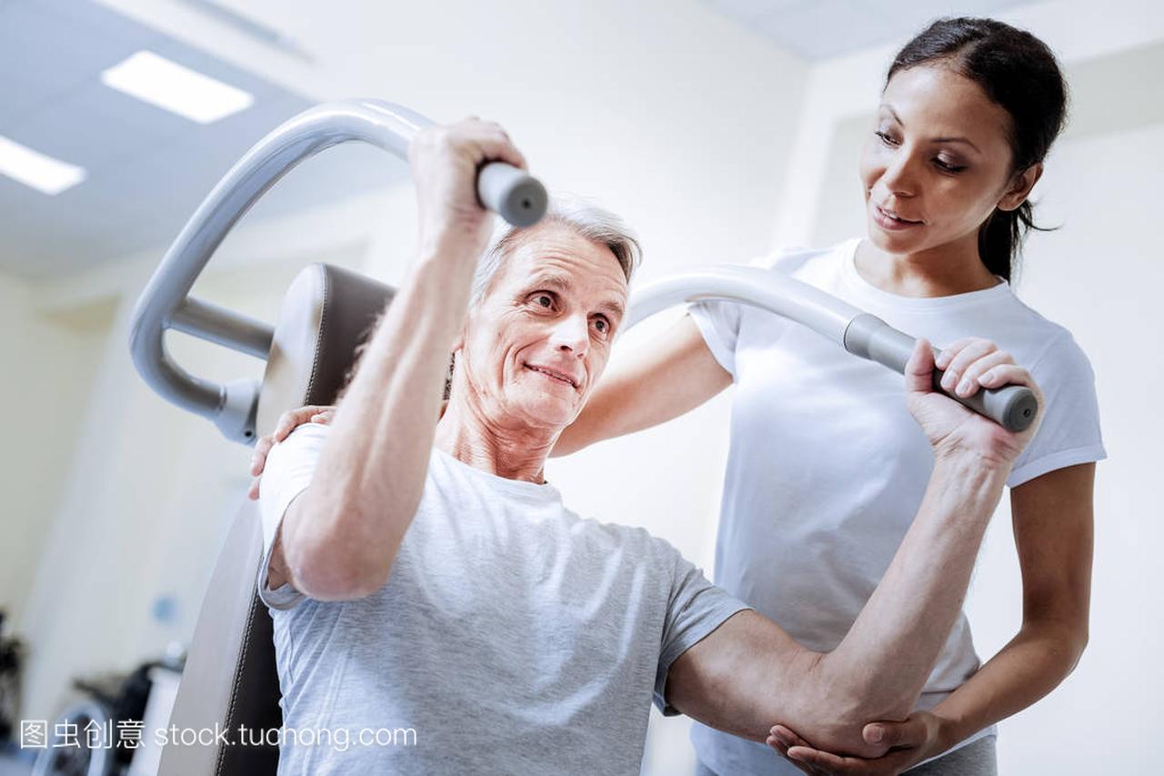 Enthusiastic pensioner using exercise equipme
