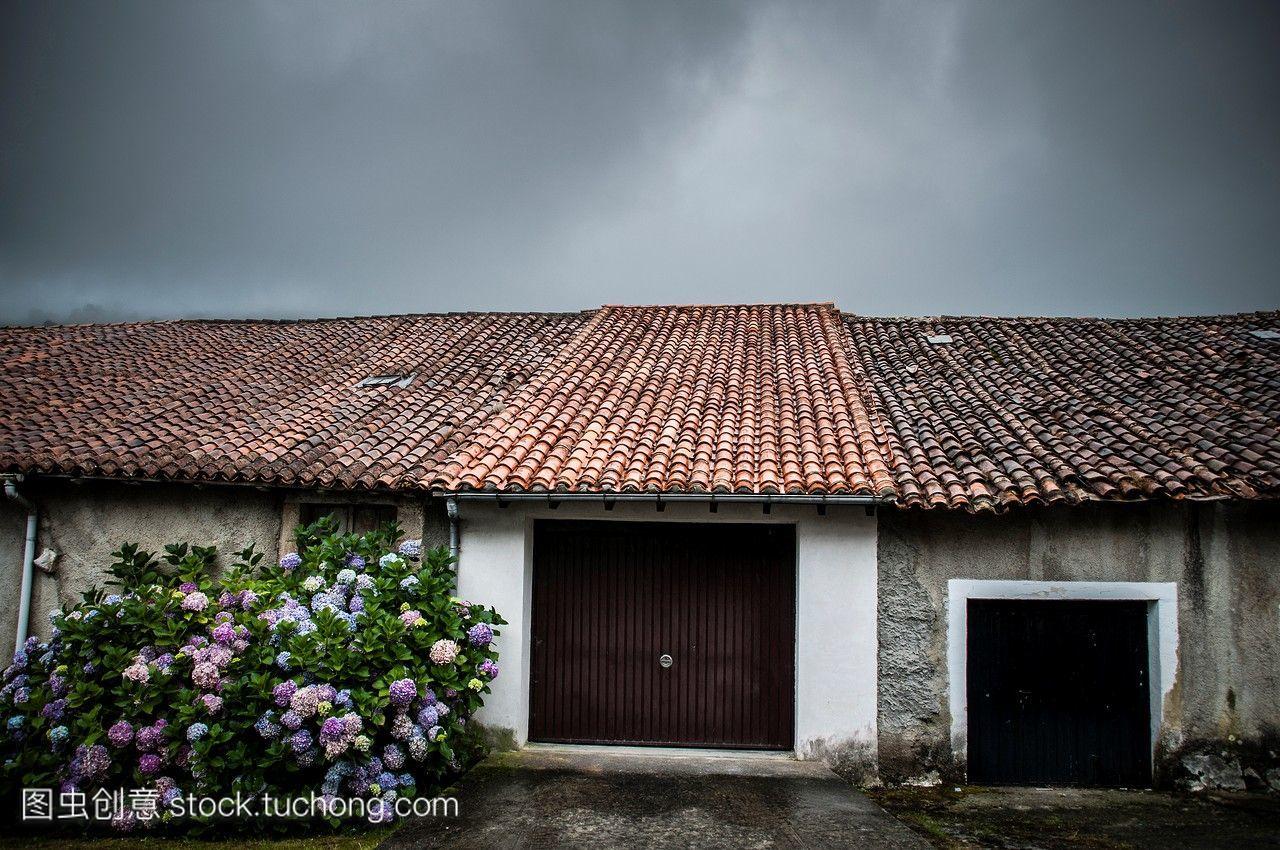 一个有典型屋顶的乡村房屋的车库,一个下雨天