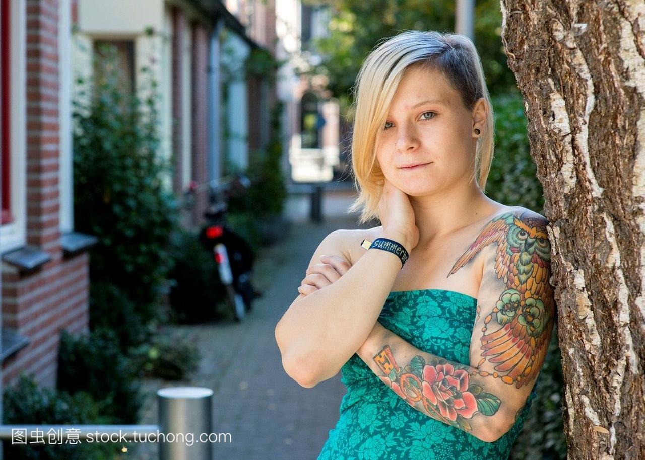 荷兰蒂尔堡。年轻的金发女人纹身在她的左胳膊