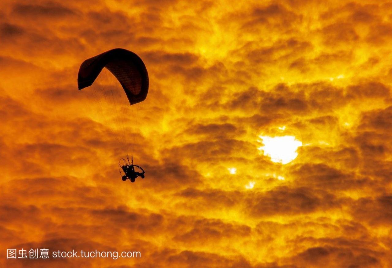 在黄金海岸的汽车滑翔机或滑翔伞飞行在村子人