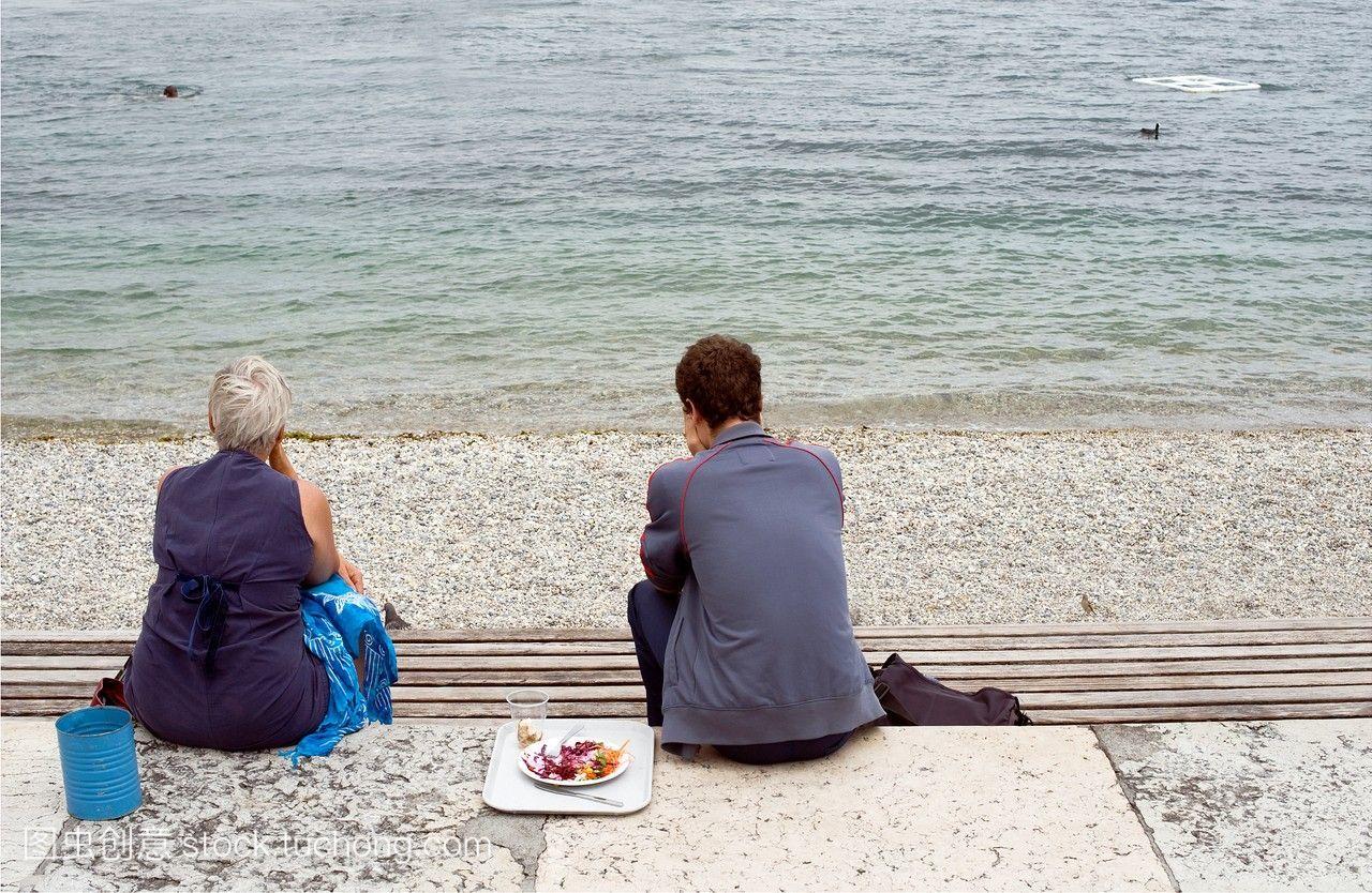 人们在日内瓦,日内瓦,瑞士的河岸上吃饭,休息,沉