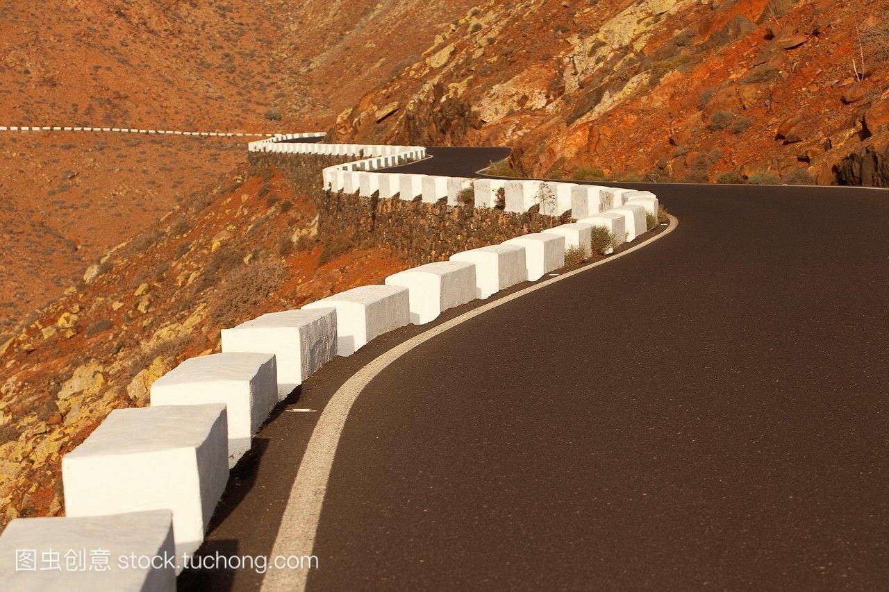 山路和白著蓝色的交通标志Fuerteventura加那利