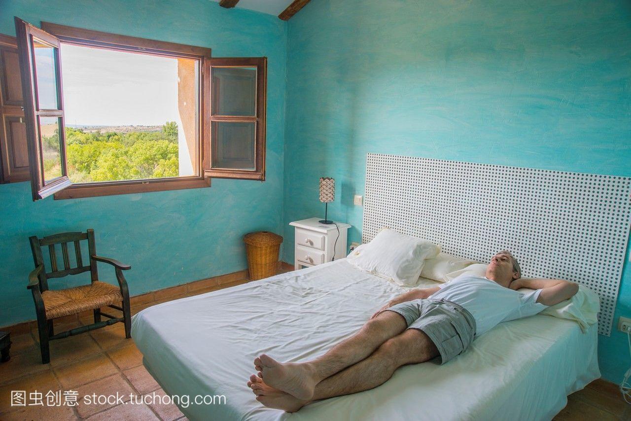 男人躺在乡村旅馆的床上。塞戈维亚西班牙。