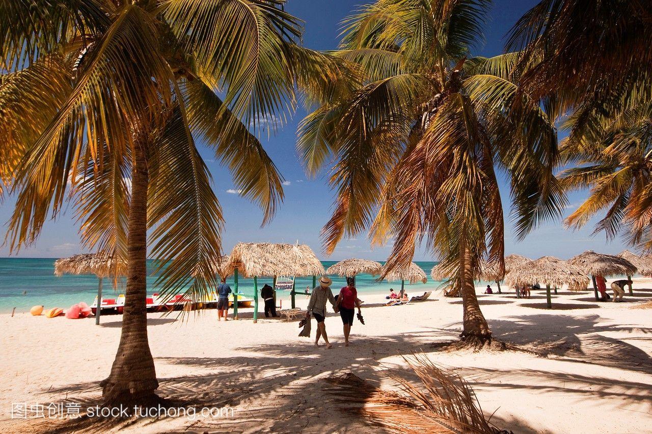 在特立尼达岛附近的playaancon海滩上，游客,阳伞和茅草伞都是神圣的