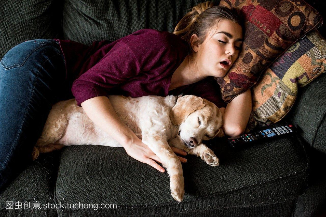 19岁的年轻女子和她的西班牙猎犬睡觉。