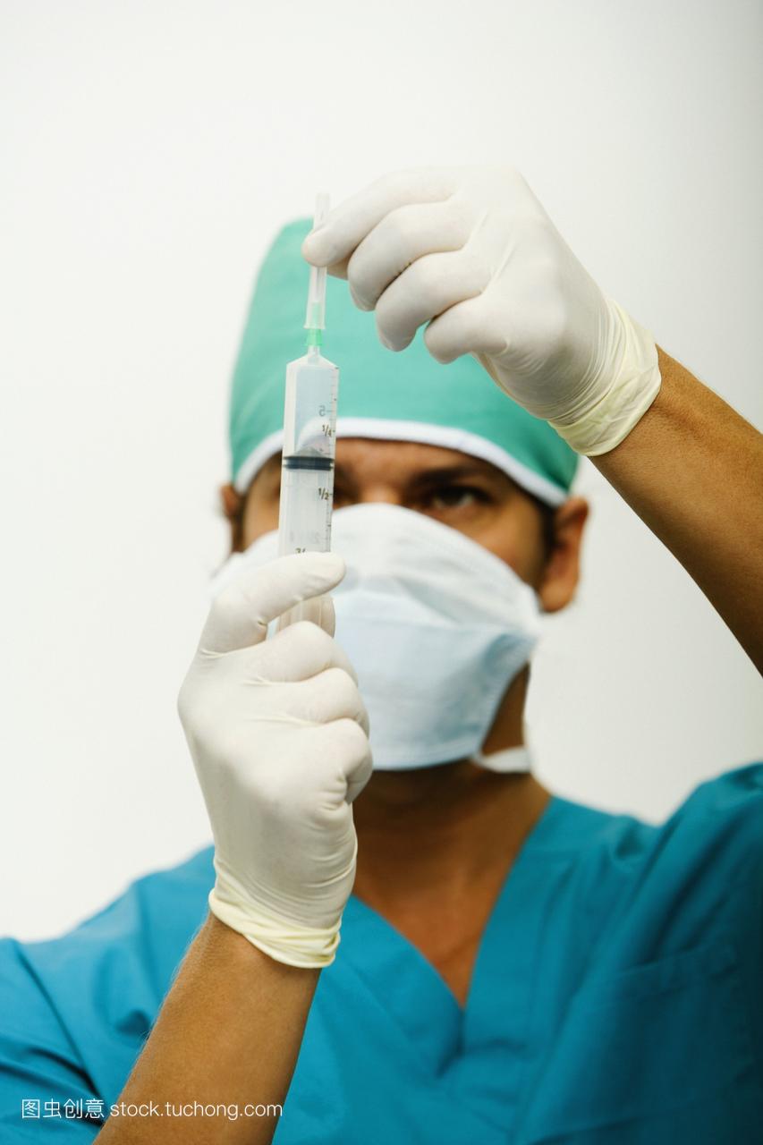 一个男外科医生拿着注射器的特写镜头