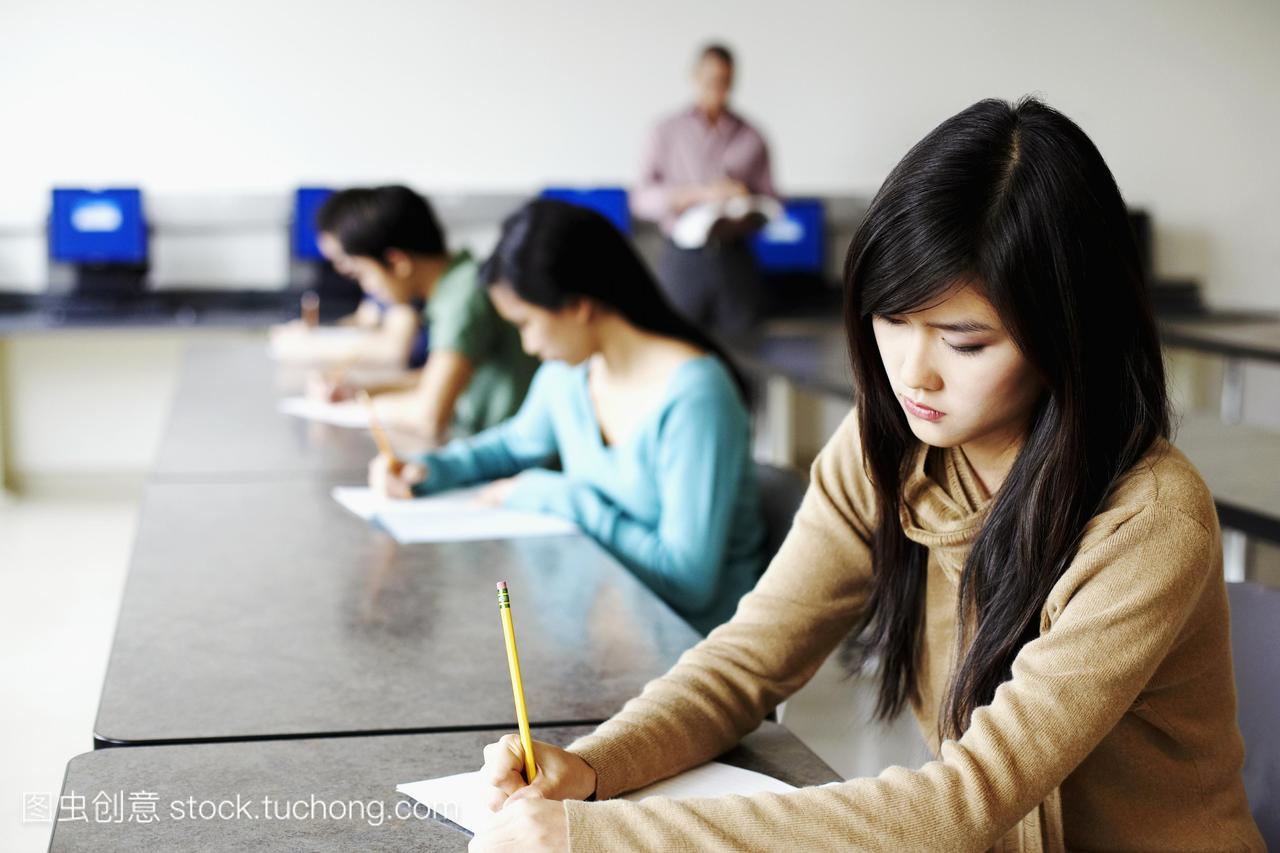 一个年轻女子在教室里考试的侧面