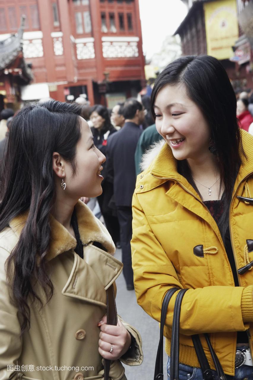 两个年轻的女人在街头市场上互相望着