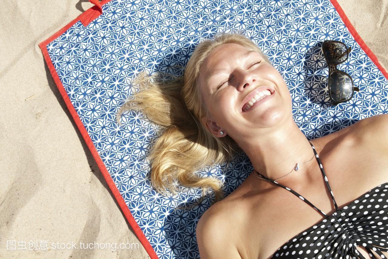 躺在沙滩上晒太阳的女人