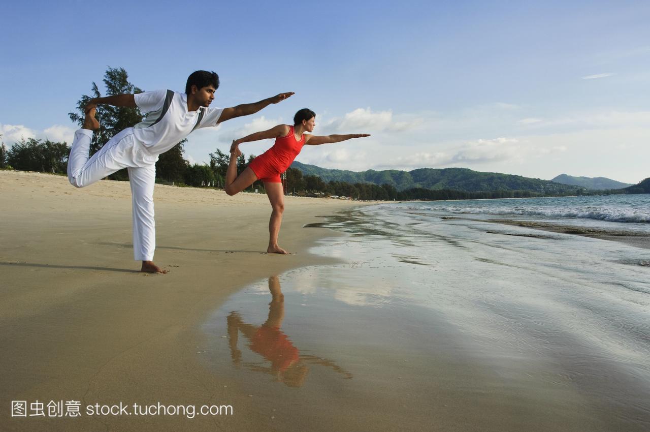 泰国人表演瑜伽在海滩上。