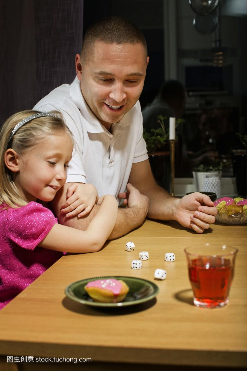 父亲和女儿在餐桌上玩骰子游戏