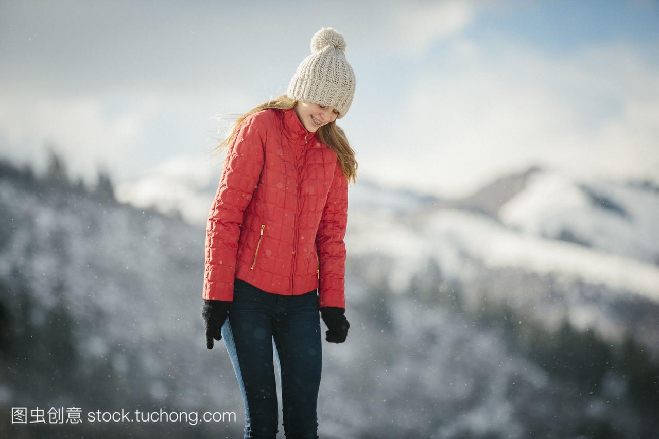 一个小女孩在一个红色外套的帽子在冬天在户外
