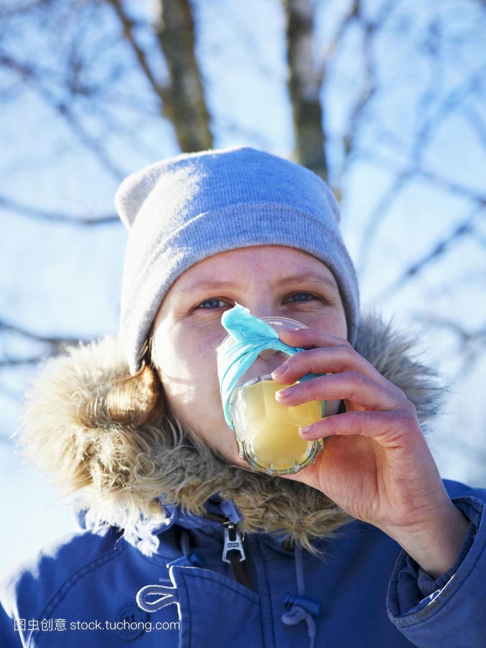 一个女人喝热柠檬水在冬季野餐